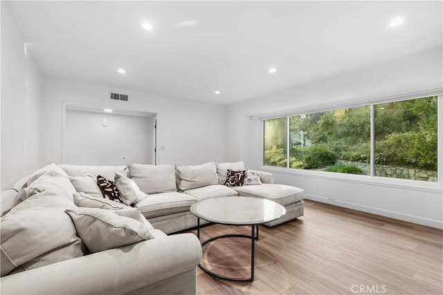 living room with recessed lighting, visible vents, baseboards, and light wood-type flooring