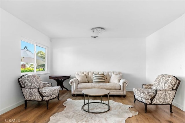 living area with visible vents, wood finished floors, and baseboards