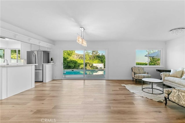 interior space featuring an inviting chandelier, a healthy amount of sunlight, and light wood-style floors