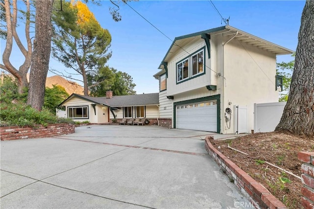 view of front of home with driveway, a garage, and fence