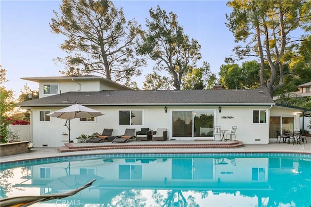 rear view of house with outdoor lounge area, an outdoor pool, stucco siding, and a patio area