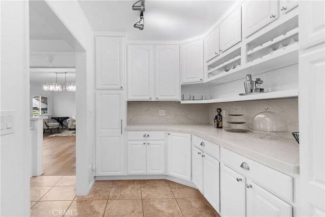kitchen with light tile patterned flooring, open shelves, white cabinets, and backsplash