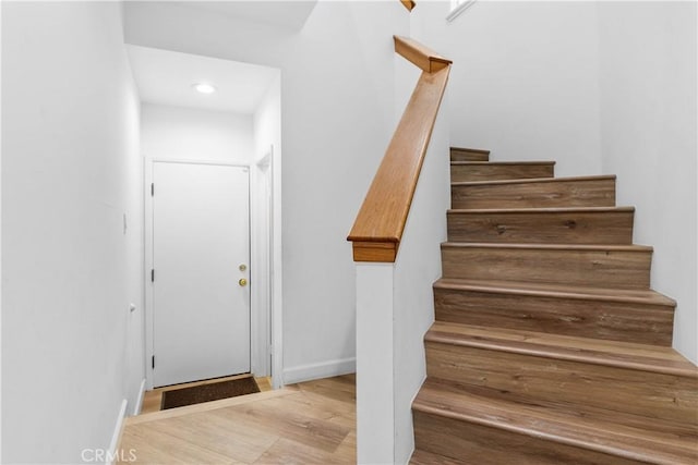 stairs featuring wood finished floors, recessed lighting, and baseboards