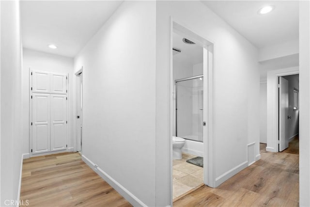hallway featuring recessed lighting, light wood-style flooring, and baseboards