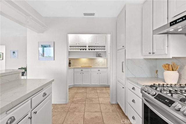 2320 Jayma Ln, La Crescenta, CA 91214 - kitchen with under cabinet range hood, decorative backsplash, white cabinetry, gas range, and light stone counters