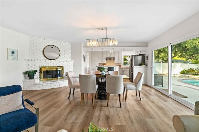 2320 Jayma Ln, La Crescenta, CA 91214 - dining room with light wood finished floors, a brick fireplace, and a chandelier