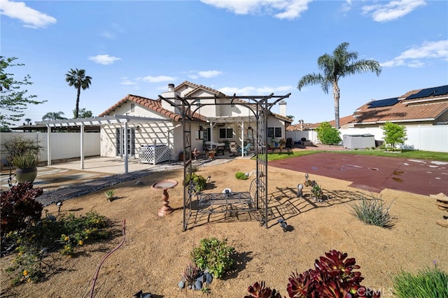 back of property with a tile roof, a pergola, a fenced backyard, and a patio area