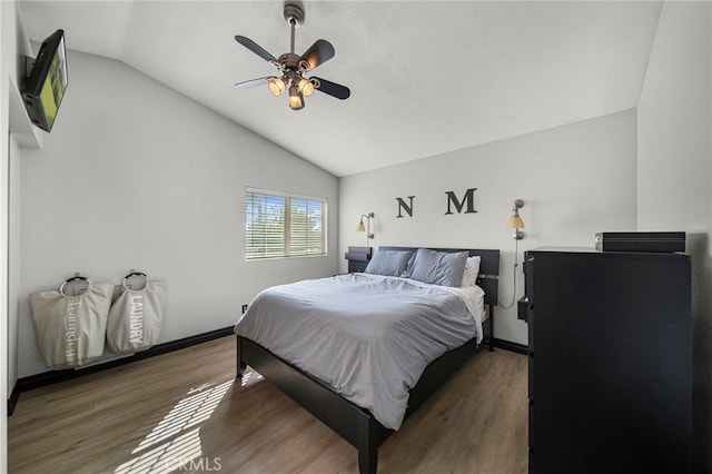 bedroom with baseboards, wood finished floors, a ceiling fan, and lofted ceiling