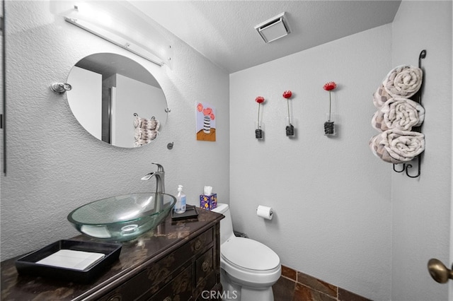 half bathroom with visible vents, toilet, and vanity