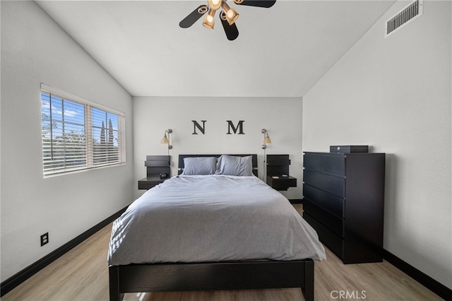 bedroom with baseboards, visible vents, a ceiling fan, and light wood-style floors