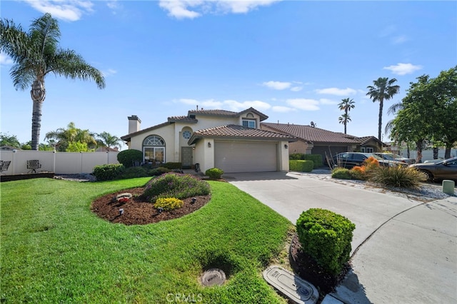 mediterranean / spanish house featuring driveway, fence, stucco siding, a front lawn, and a garage