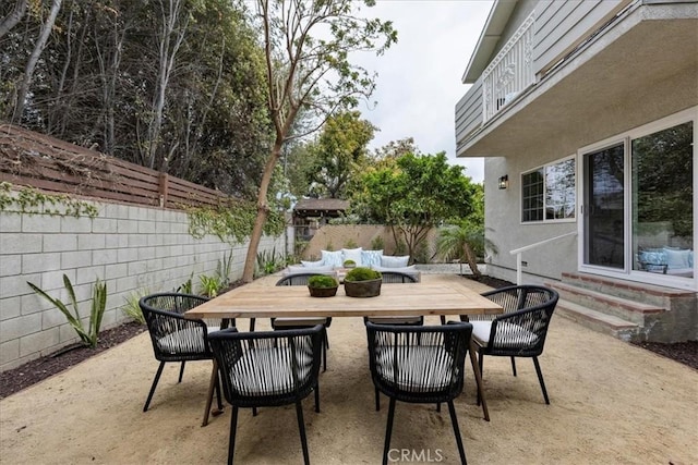 view of patio / terrace with outdoor dining area, a fenced backyard, and entry steps