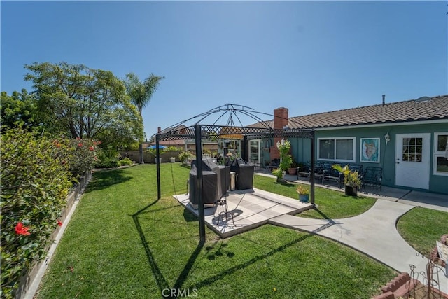 back of property featuring a fenced backyard, stucco siding, a yard, a gazebo, and a patio area