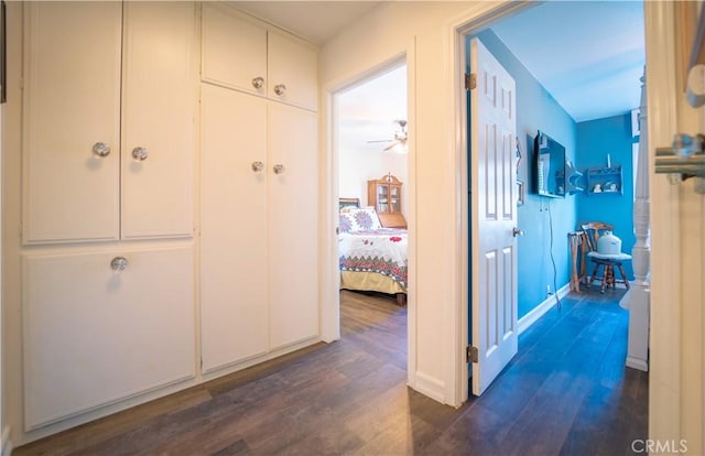 hall featuring dark wood finished floors and baseboards