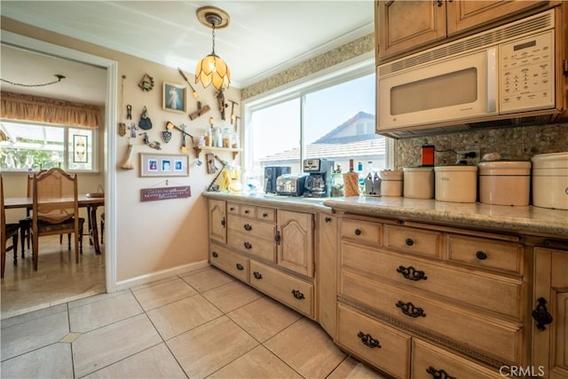 kitchen featuring tasteful backsplash, white microwave, baseboards, pendant lighting, and ornamental molding