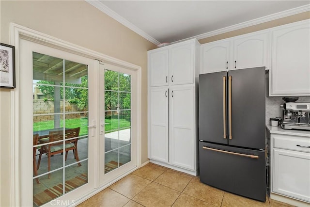 2548 S Young Ct, San Bernardino, CA 92408 - kitchen featuring crown molding, light tile patterned flooring, light countertops, freestanding refrigerator, and white cabinetry