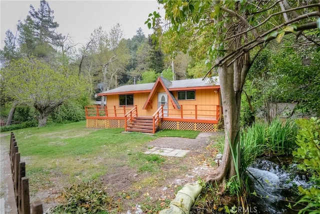 14109 Meadow Ln, Lytle Creek, CA 92358 - view of front of property with a wooded view, a front yard, and a wooden deck