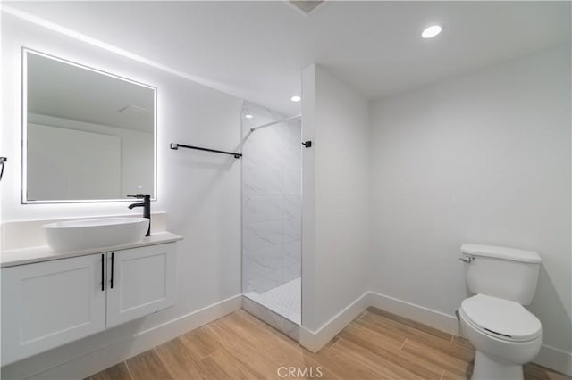 5652 La Mirada Ave, Los Angeles, CA 90038 - bathroom featuring toilet, wood finished floors, baseboards, and tiled shower