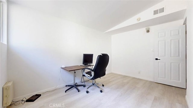 office with visible vents, light wood-style flooring, vaulted ceiling, and baseboards