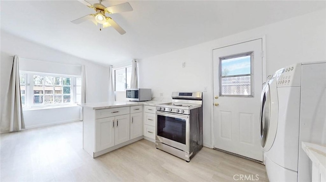 kitchen featuring stainless steel microwave, electric stove, vaulted ceiling, washer / dryer, and a peninsula