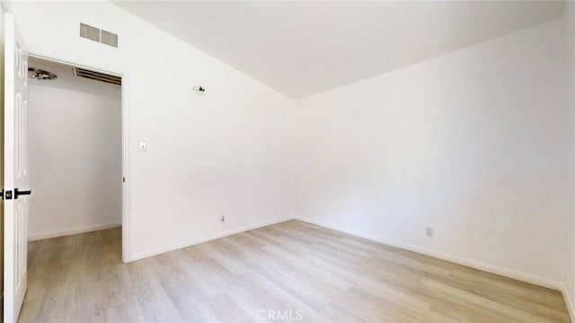 unfurnished room featuring visible vents, light wood finished floors, and baseboards