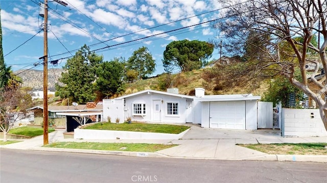 ranch-style house featuring a chimney, stucco siding, fence, a garage, and driveway