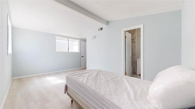 bedroom with vaulted ceiling with beams, wood finished floors, connected bathroom, baseboards, and visible vents
