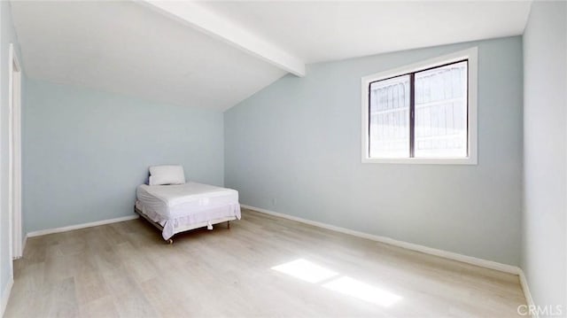 bedroom featuring baseboards, wood finished floors, and vaulted ceiling with beams