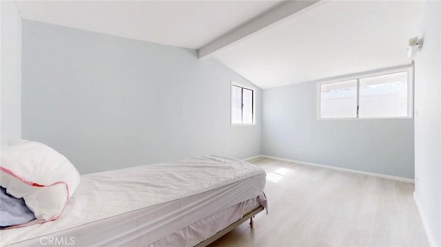 bedroom with lofted ceiling with beams, wood finished floors, and baseboards