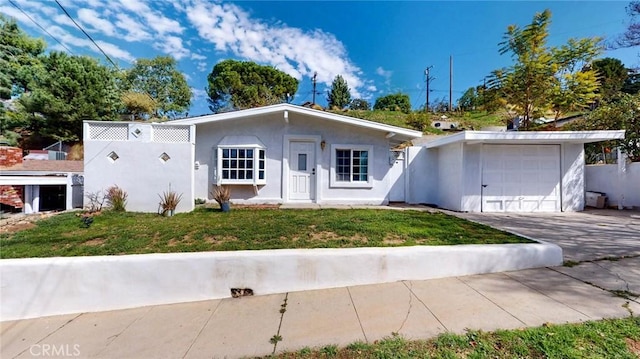 view of front of house with driveway, a front yard, stucco siding, and a garage