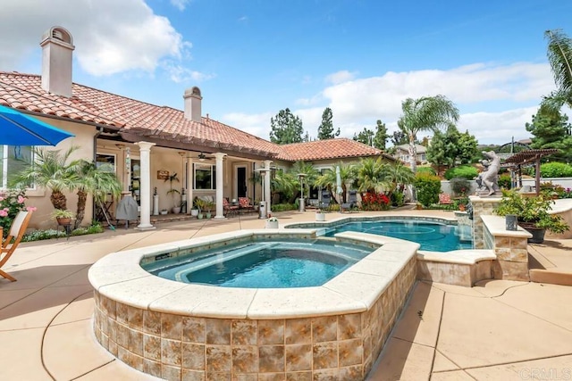 view of swimming pool featuring a pergola, ceiling fan, a pool with connected hot tub, and a patio area