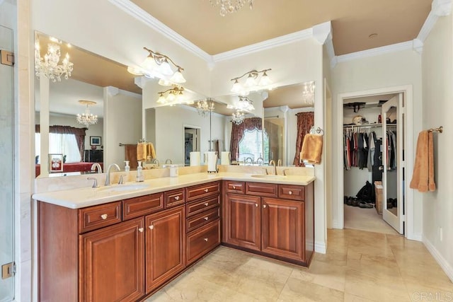 bathroom featuring crown molding, a sink, a chandelier, and double vanity