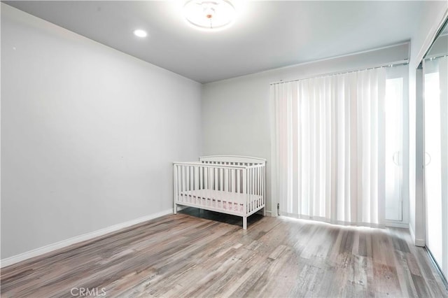 unfurnished bedroom with baseboards, recessed lighting, and wood finished floors