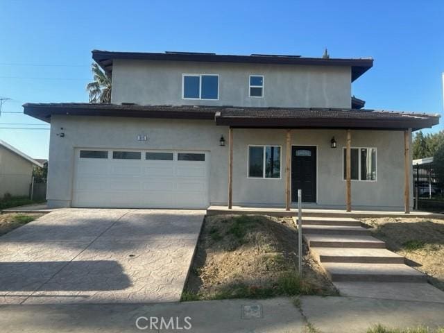 traditional home with stucco siding, covered porch, driveway, and an attached garage