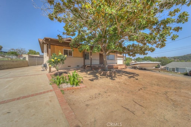 view of front of property featuring fence, driveway, a porch, and crawl space