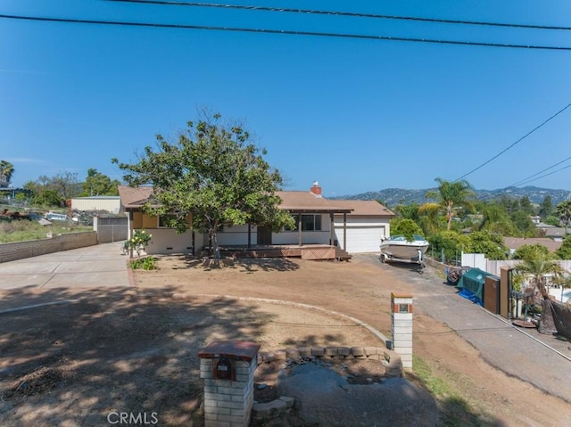 view of front of property featuring fence, driveway, a mountain view, and a garage