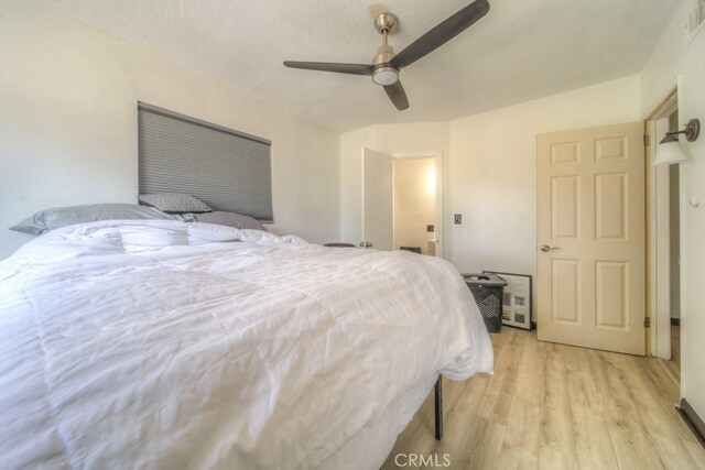 bedroom with a ceiling fan, visible vents, and light wood-style flooring