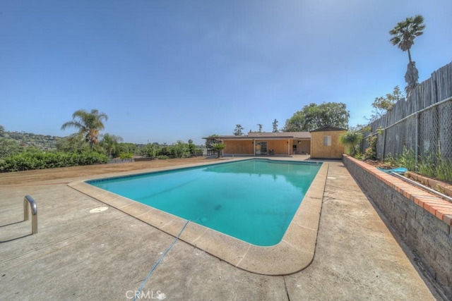 pool featuring fence and a patio