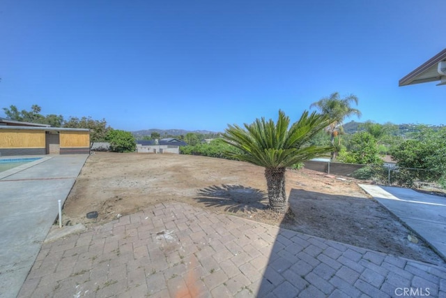 view of yard with a patio, a mountain view, and fence