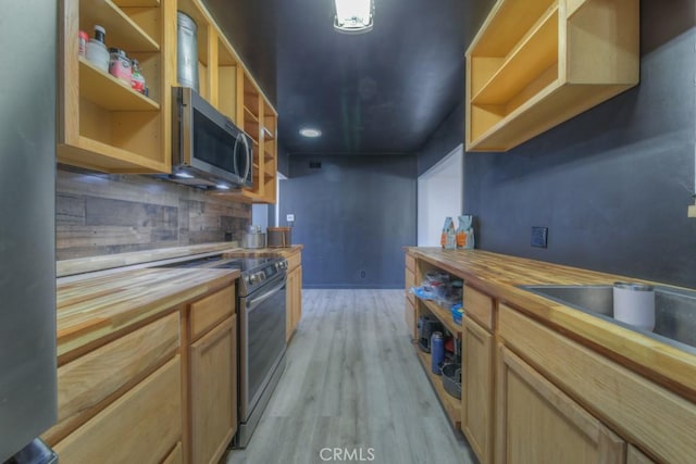 kitchen featuring stainless steel appliances, open shelves, wooden counters, backsplash, and light wood-type flooring