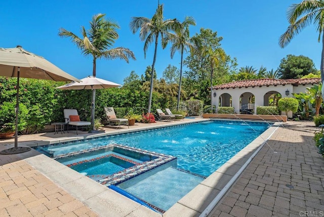 view of pool with a pool with connected hot tub and a patio area