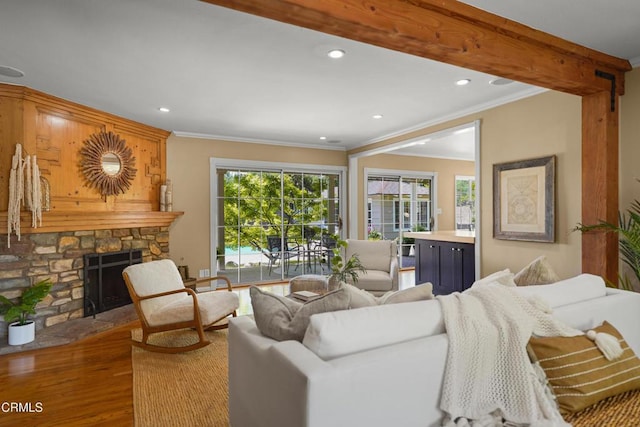 living room with recessed lighting, wood finished floors, a fireplace, and crown molding