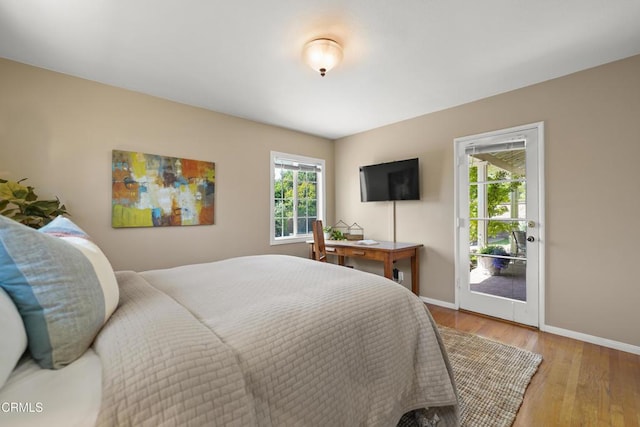 bedroom featuring baseboards, light wood-type flooring, and access to exterior