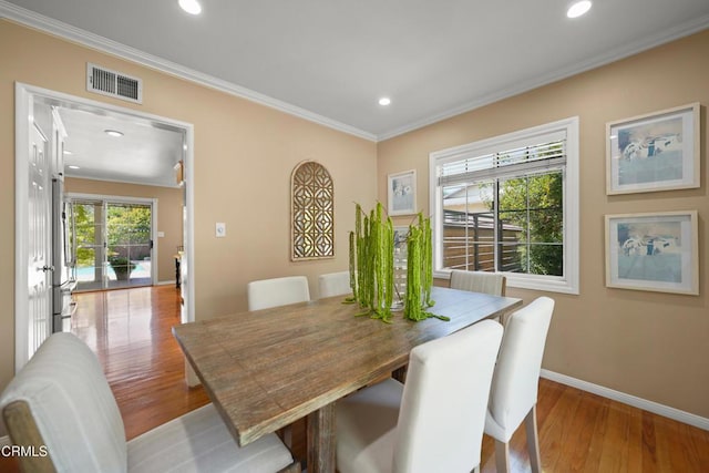 dining space featuring visible vents, baseboards, recessed lighting, ornamental molding, and wood finished floors