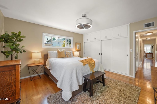 bedroom featuring baseboards, visible vents, a closet, and light wood-style flooring