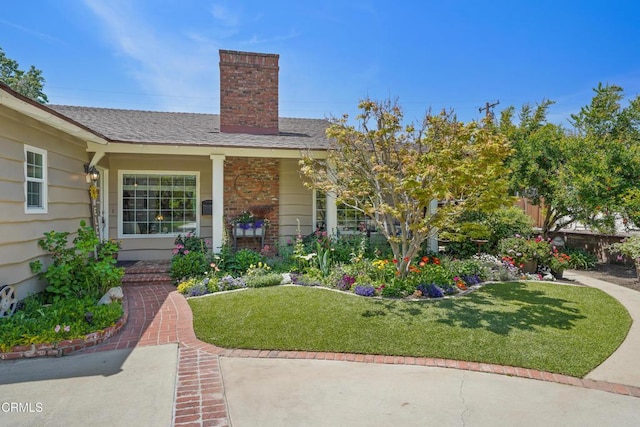 view of front facade featuring a chimney, fence, a shingled roof, and a front yard
