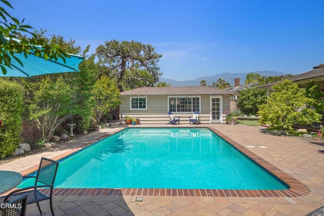view of swimming pool featuring a mountain view, a fenced in pool, a fenced backyard, and a patio area
