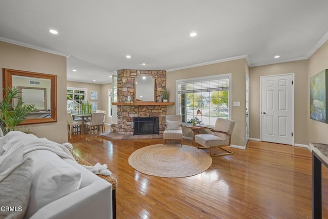 living room featuring baseboards, a fireplace, crown molding, and plenty of natural light