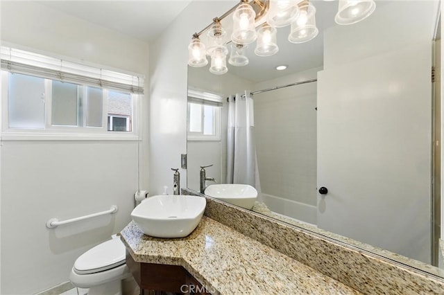 bathroom with toilet, vanity, and a chandelier