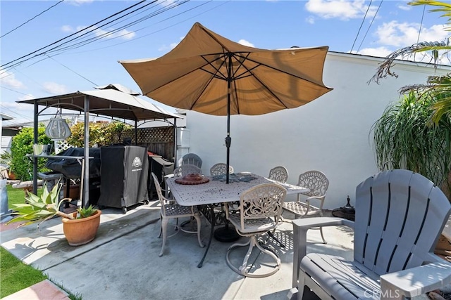 view of patio with outdoor dining area, a gazebo, and fence
